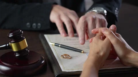 Signing divorce document. Wedding rings and gavel with a woman signing a co.. Stock Footage 287547375