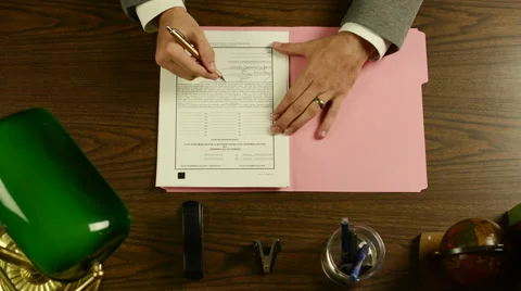 SIGNING DOCUMENT AT DESK Stock Footage 46625475