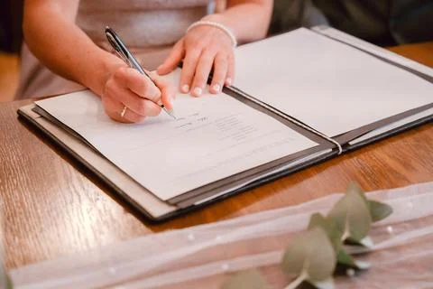 Signing a Document at a Wooden Table Foto stock