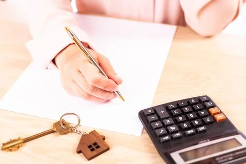 Signing a home mortgage agreement, a woman signs a mortgage agreement, a close Stock Photos
