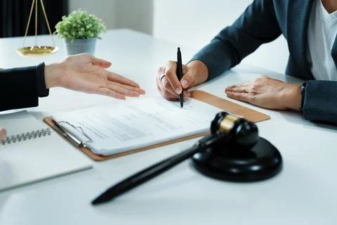 The signing of important documents between the lawyer and the client to enter Stock Photos