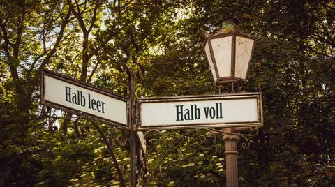 Signposts the direct way to half full versus half empty - Bildmontage An i... Stock Photos