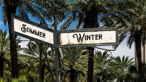 Signposts the direct way to winter versus summer Stock Photos