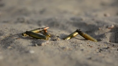 Signs of war. Empty bullet cases on the sand	 動画素材 91061483