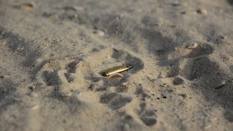 Signs of war. Empty bullet cases on the sand	 Vidéo 91061727