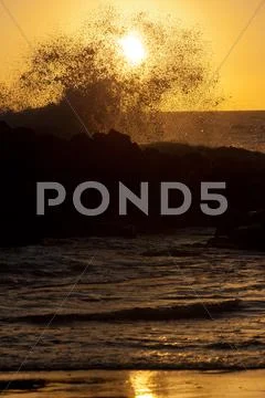 Sihouette of a wave at sunset Stock Photos