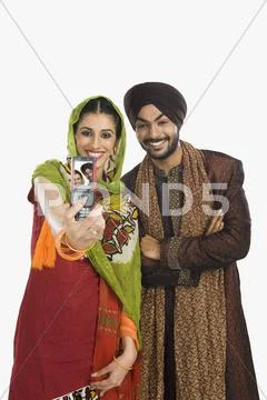 Sikh couple taking a picture of themselves with a mobile phone Stock Photos