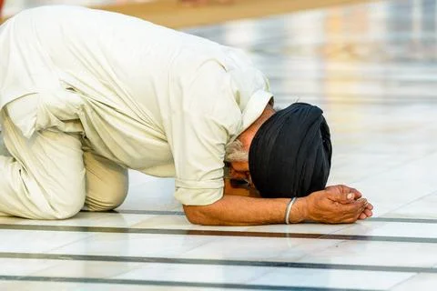 A Sikh devotee is praying at the holy pool of the Harmandir Sahib, the Gol... Stock Photos