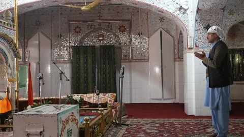 A Sikh devotee praying inside Gurdwara Panja Sahib Stock Footage 86660262