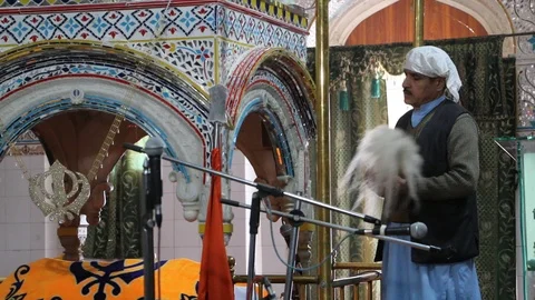 Sikh devotees fanning doing Chaur Sahib inside Gurdwara Panja Sahib Stock Footage 86659474
