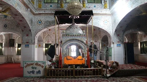 Sikh devotees fanning doing Chaur Sahib inside Gurdwara Panja Sahib Stock Footage 86659562