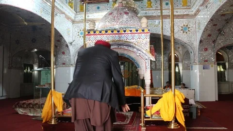 A Sikh pilgrim prostrating inside Gurdwara Panja Sahib Stock Footage 86659138
