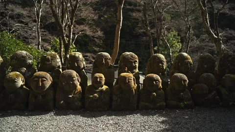 Silent Buddhist Stone Figures in Mossy Woodland Shrine Stock Footage 331557560
