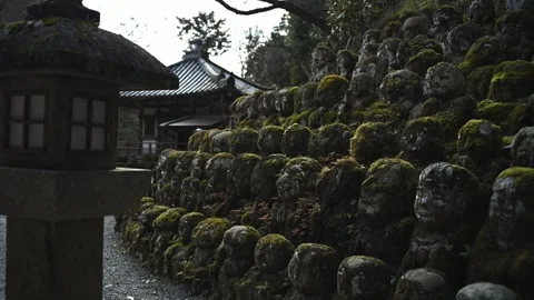 Silent Buddhist Stone Figures in Mossy Woodland Shrine Stock Footage 331557589