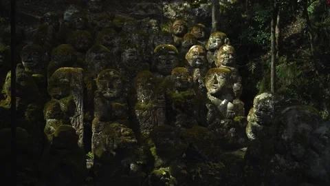 Silent Buddhist Stone Figures in Mossy Woodland Shrine Stock Footage 331557636