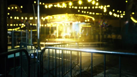 Silent fairground with glowing carousel behind secure metal fencing Stock-Footage 341564969