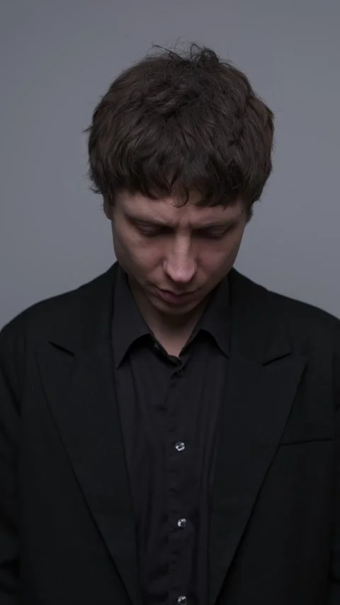 Silent sadness, man looking down with subtle emotional pain and disappointment Stock Footage 323464604