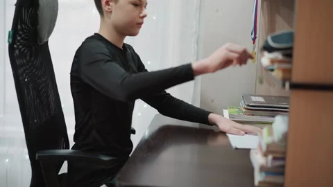Silent student diligently taking notes. Young learner fully engaged in academic 動画素材 345147477