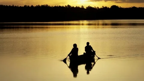 Silhouette of active senior Caucasian American couple outdoors in the boat on Stock Footage