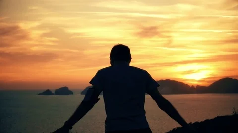 Silhouette of active young man stretching doing yoga exercise on top of a Vídeo Stock 84189713