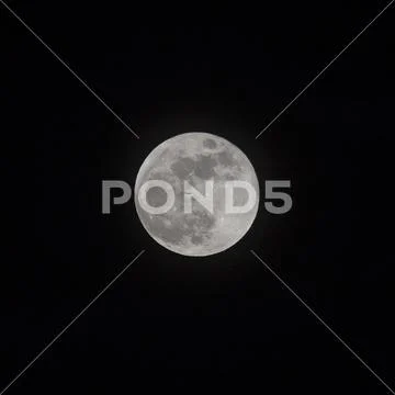 Silhouette of an aeroplane crossing the face of the full moon Stock Photos