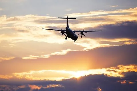 Silhouette of the airplane at the sunset Stock Photos