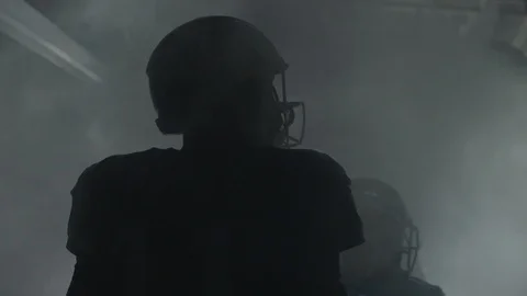 Silhouette of American football player in a foggy tunnel before match Stock Footage