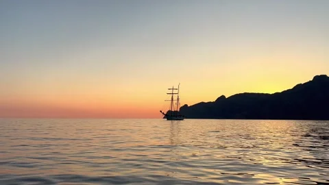 Silhouette of ancient sailing ship navigating at sunset seen from moving boat 動画素材 278958212