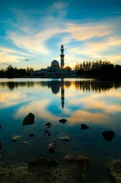 Silhouette and reflection of floating mosque over magical sunset background Stock Photos