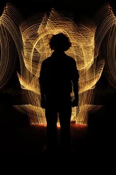 Silhouette of anonymous man standing in front of golden glowing lines. everyt Stock Photos