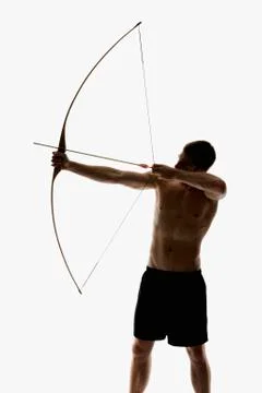 Silhouette of archer pulling an arrow back on his longbow Stock Photos
