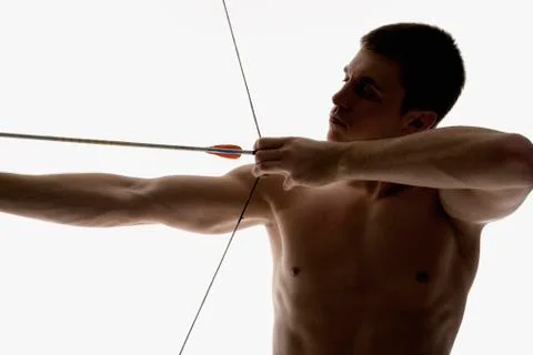 Silhouette of archer pulling an arrow back on his longbow Stock Photos