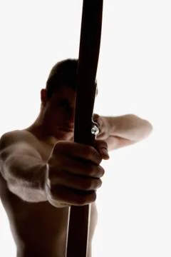 Silhouette of archer pulling an arrow back on his longbow Stock Photos