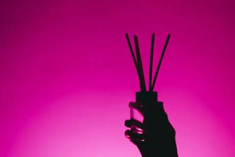 Silhouette of aroma diffuser in a female hand isolated on a pink background Foto stock