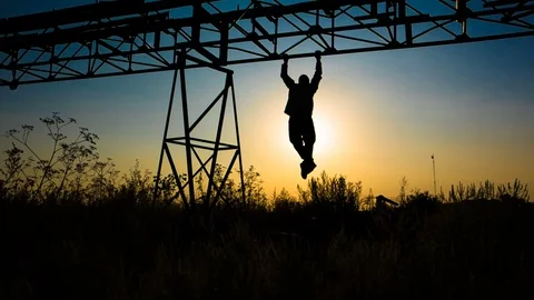Silhouette of an athlete who pull-ups on a metal frame. Young man doing pull-ups 스톡 동영상 79538987