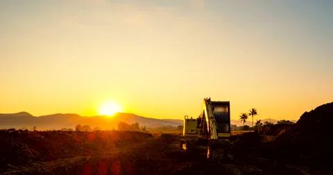 A Silhouette Backhoe in a construction site during sunset or sunrise Stock Footage 289354283