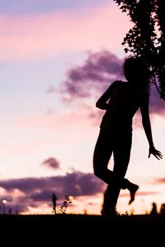 Silhouette from a ballet dancer during the dusk or sunset happy positive motion Stock Photos