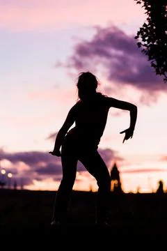 Silhouette from a ballet dancer during the dusk or sunset happy positive motion Stock Photos