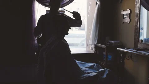 Silhouette of the Barber and the client in front of the window in the barbershop Stock-Footage 100639957