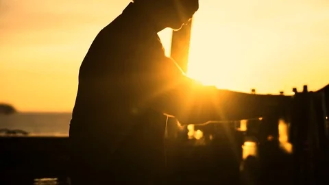 Silhouette of barman preparing cocktail at sunset outside Stock Footage 75002241