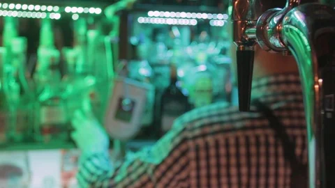 Silhouette of bartender back choosing alcoholic drinks bootles with beer tower Stock Footage 84762130