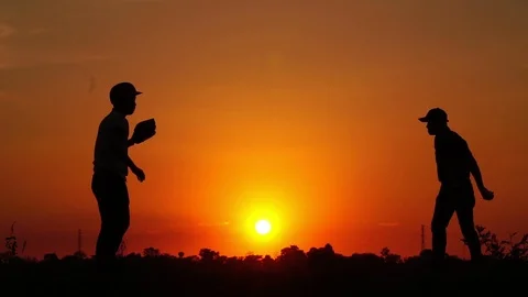 Silhouette baseball, two men were practicing throwing a baseball  Stock Footage 112949963
