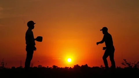 Silhouette baseball, two men were practicing throwing a baseball  Stock Footage 112950029