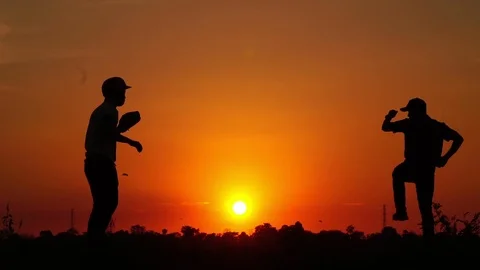 Silhouette baseball, two men were practicing throwing a baseball  Stock Footage 112950048