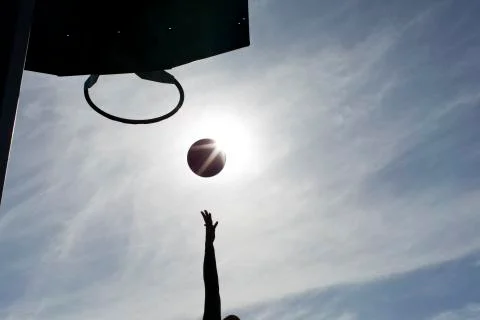 Silhouette of a basketball player's arm reaching out to score Stock Photos