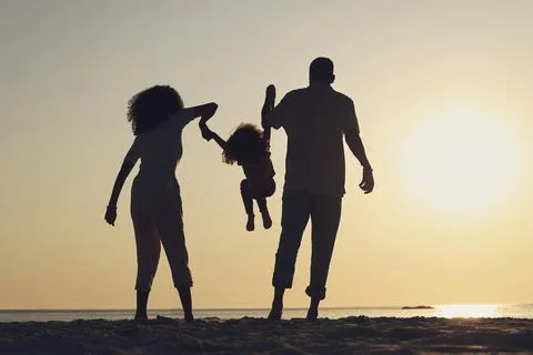 Silhouette, beach and a family with children by the ocean, playing together in Stock Photos
