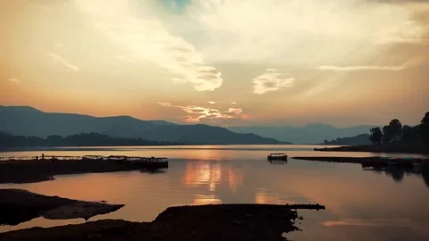 Silhouette of a Bench by the River Under an Orange Sky with Waves Stock Footage 287747283