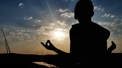 Silhouette of a Boy on the Background of Sunset Meditating Sitting Stock Footage 67263168