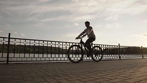 Silhouette of boy on bicycle Stock Footage 130001227