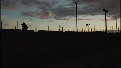 The silhouette of a boy taking a picture with a reflex camera at sunset. Stock Footage 86556802